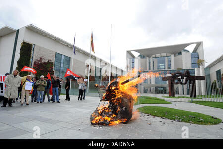 Manifestanti masterizzare un finto serbatoio nella parte anteriore della cancelleria durante una dimostrazione contro la distribuzione della Bundeswehr (tedesco forze armate) in Afghanistan, Berlino, 08 ottobre 2011. I manifestanti richiedono l'immediato e incondizionato ritiro delle truppe. Essi assemblati a Potsdamer Platz e reso il loro cammino verso la Cancelleria tedesca. L'international Afghanistan missi Foto Stock