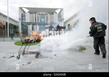 Manifestanti masterizzare un finto serbatoio nella parte anteriore della cancelleria durante una dimostrazione contro la distribuzione della Bundeswehr (tedesco forze armate) in Afghanistan, Berlino, 08 ottobre 2011. I manifestanti richiedono l'immediato e incondizionato ritiro delle truppe. Essi assemblati a Potsdamer Platz e reso il loro cammino verso la Cancelleria tedesca. L'international Afghanistan missi Foto Stock