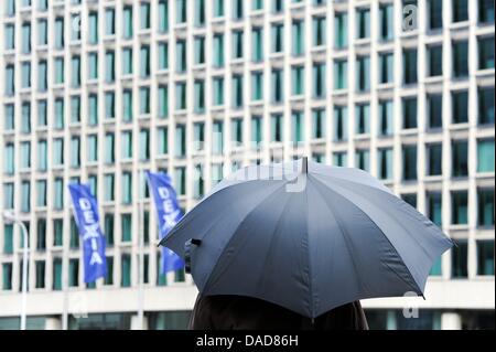 Un pedone con ombrello si trova di fronte alla sede del Dexia-Group a Bruxelles, Belgio, 11 ottobre 2011. La crisi del debito nell’Eurozona si è aggravata negli ultimi giorni. Tre anni dopo la crisi dei mercati finanziari, le banche devono ancora una volta essere salvate. Il gruppo belga-francese Dexia sarà disgregato e parzialmente nazionalizzato. Foto: FKPH Foto Stock