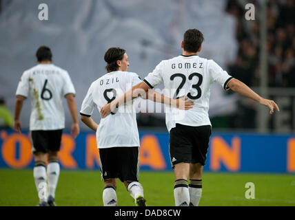 La Germania Khedira Sami (L-R), Mesut Oezil e marcatore Mario Gomez celebrare il 3-0 obiettivo durante il Gruppo A EURO 2012 partita di qualificazione tra la Germania e il Belgio presso la Esprit Arena a Duesseldorf in Germania, 11 ottobre 2011. Foto: Bernd Thissen dpa/lnw +++(c) dpa - Bildfunk+++ Foto Stock