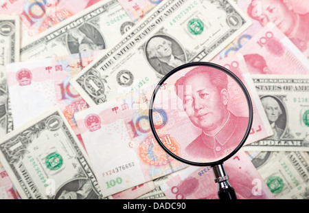 Concentrandosi sui yuan cinese contro di noi e monete cinesi sullo sfondo Foto Stock