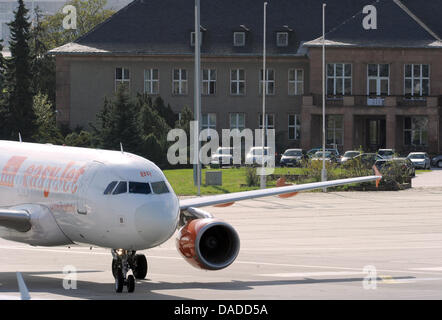 Un airbus rotoli oltre l'ex air terminal per la Germania orientale aerei governativi all'aeroporto di Schönefeld, Germania, 13 ottobre 2011. L'edificio sarà abbattuto quando il nuovo aeroporto di BER è aperto. Il nuovo Willy Brandt Airport, che si aprirà il 03 giugno 2012, gestirà 27 milioni di passeggeri a Berlino una volta l'anno. Foto: Bernd Settnik Foto Stock