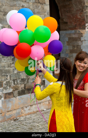 Ragazza vietnamita con palloncini sul terreno della cittadella di Thang ad Hanoi, Vietnam Foto Stock