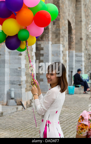 Ragazza vietnamita con palloncini sul terreno della cittadella di Thang ad Hanoi, Vietnam Foto Stock