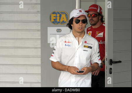 Mexican driver di Formula Uno Sergio Perez della Sauber (L) e lo spagnolo Fernando Alonso della Ferrari di ritorno dalla parata dei piloti in pista Buddh International Circuit, maggiore noida, India, 30 ottobre 2011. Il primo Gran Premio di Formula Uno di India avrà luogo il 30 ottobre 2011. Foto: David Ebener dpa Foto Stock