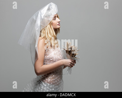 Donna che indossa Bubble wrap vestito di sposa Foto Stock