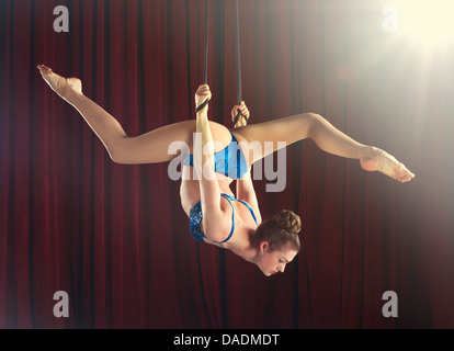 Femmina trapezista esecuzione si divide su funi Foto Stock