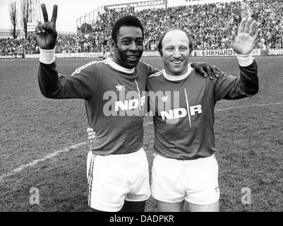 (Dpa) file - un file immagine datata 21 aprile 1975 mostra la Germania onorario di capitano di una squadra Uwe Seeler (R) e il Brasile è leggenda del calcio Pele abbracciando e agitando prima di una partita di beneficenza in Braunschweig, Germania. Il 05 novembre 2011, Uwe Seeler spire 75. Foto: Wolfgang Weihs Foto Stock