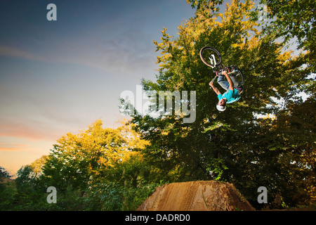 Rider BMX eseguendo capovolto stunt metà aria Foto Stock