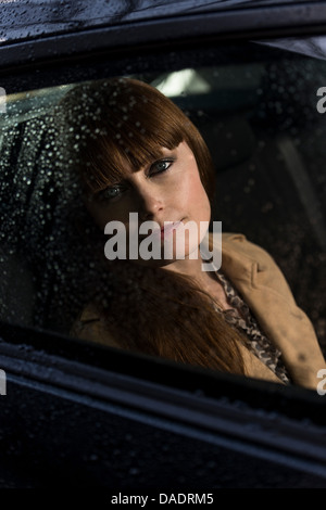 Business donna guardando fuori della finestra auto