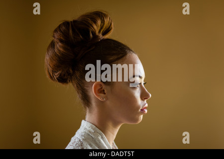 Close up ritratto di una giovane donna con i capelli in un panino Foto Stock