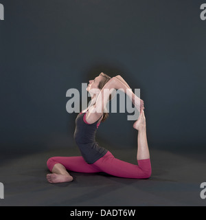 Studio shot di metà donna adulta in posizione di yoga Foto Stock