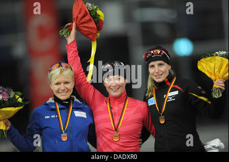 Velocità tedesco skater Claudia Pechstein celebra la venuta in primo luogo in campo femminile 3000 metri di gara durante il premio alla cerimonia al regime tedesco Skating Championships a Inzell, Germania, 04 novembre 2011. A sinistra si erge la seconda Isabell Ost e destra sorge il terzo posto Bente Kraus. Foto: Andreas Gebert Foto Stock