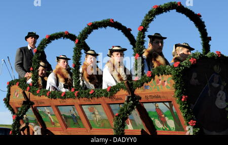 Frauen mit Trachten sitzen am Sonntag (06.11.2011) bei der traditionellen Leonhardifahrt in Murnau (Alta Baviera) auf einem dekorierten Pferdewagen. Die Brauchtumsveranstaltung wird zu Ehren des patrons der Stalltiere in vielen bayerischen Orten begangen. Foto: Tobias Hase dpa/lby Foto Stock