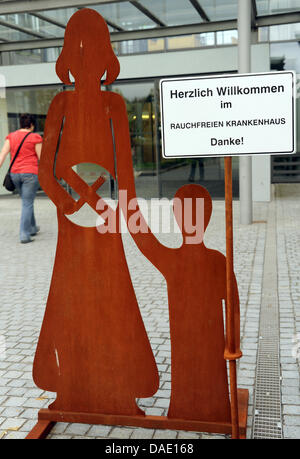 Una donna cammina davanti ad una lettura del segno "Benvenuti al fumo-ospedale gratuito. Grazie!" presso il Park Hospital Clinic per bambini e adolescenti, psichiatria e psicosomatica psicoterapia a Leipzig, Germania, 05 ottobre 2011. Un ricoverato la terapia è stata offerta per computer e internet addicted i bambini e giovani per un paio di mesi. Gli obiettivi del trattamento sono controllati contatto e ragionevole Foto Stock