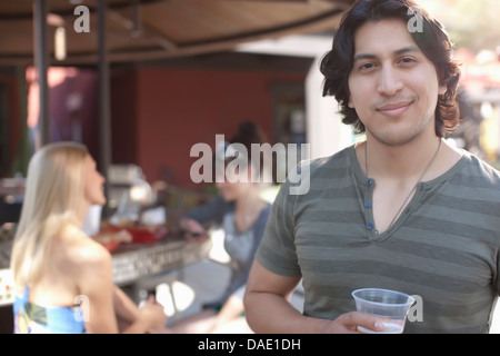Giovane azienda bere e sorridente in outdoor cafe, ritratto Foto Stock