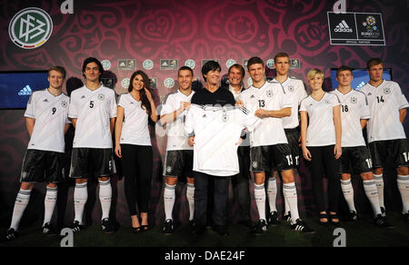 Il tedesco allenatore nazionale Joachim Loew (C) e i giocatori della squadra nazionale presente il nuovo Euro 2012 maglie presso una concessionaria auto ad Amburgo, Germania, 09 novembre 2011. Andre Schuerrle (L-R), Mats Hummels, una hostess, Lukas Podolski, Joachim Loew, Thomas Mueller, Per Mertesacker, un altro hostess, Toni Kroos e Holger Badstuber pongono per la fotocamera. La selezione tedesca si giocano la Ukr Foto Stock