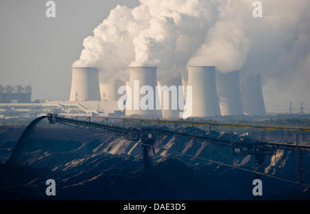 Il marrone fumo centrali a carbone vegetale di Vattenfall AG power company è visto dietro un nastro trasportatore ponte del carbone marrone striscia in miniera Jaenschwalde, Germania, 11 novembre 2011. In vista della conferenza mondiale sul clima entro la fine di novembre a Durban, Sud Africa, testimoni di cambiamento climatico da paesi in via di sviluppo hanno visitato la Vattenfall brown centrali a carbone vegetale in Jaenschwal Foto Stock