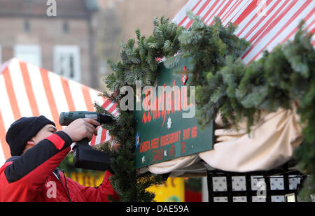 Un uomo imposta la decorazione su uno stand del Christkindlesmarkt a Norimberga, Germania, 14 novembre 2011. Il 25 novembre 2011, il mercato sarà ufficialmente aperta con il prologo di Norimberga Cristo Bambino. Tradizionalmente, i visitatori possono godere di mercato le attrazioni, cibo e merci fino a quando la vigilia di Natale. Foto: Daniel Karmann Foto Stock