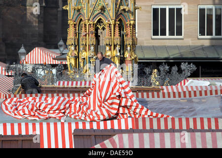 Un uomo lavora sul tetto di una cabina presso il Christkindlesmarkt a Norimberga, Germania, 14 novembre 2011. Il 25 novembre 2011, il mercato sarà ufficialmente aperta con il prologo di Norimberga Cristo Bambino. Tradizionalmente, i visitatori possono godere di mercato le attrazioni, cibo e merci fino a quando la vigilia di Natale. Foto: Daniel Karmann Foto Stock