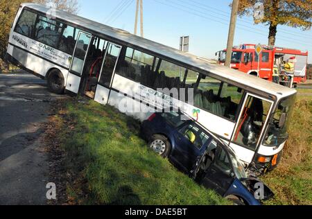 Un bus e una vettura si è bloccato in un fossato in Schermbeck, Germania, 14 novembre 2011. Il bus ha colpito la vettura e di entrambi i veicoli hanno spinto nella fossa. Il pilota di auto e il suo bambino sono rimasti feriti. Sul bus sat tre bambini che non erano stati feriti e potrebbero essere prelevati dai loro genitori. Il conducente di bus è rimasto anche entrambi incolumi. Foto: Guido Schulmann Foto Stock