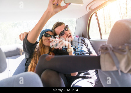 Giovane su backseat in auto stessi fotografando Foto Stock