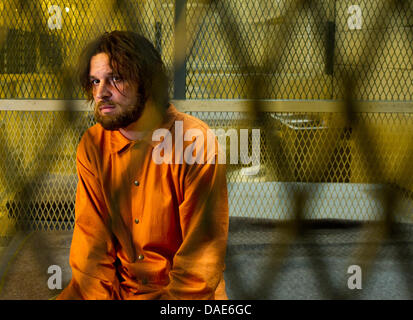 Attore Sascha Alexander Gersak come Murat Kurnaz siede in un set di una cella come un prigioniero di Guantanamo durante una sessione di stampa circa le riprese di "5 Jahre' ('5 anni") a Babelsberg Studios di Potsdam, Germania, 15 novembre 2011. Il filmato è di circa un innocente uomo Tedesco-turco, che è stato imprigionato per cinque anni presso il campo di prigionia di Guantanamo. Foto: Patrick Pleul Foto Stock