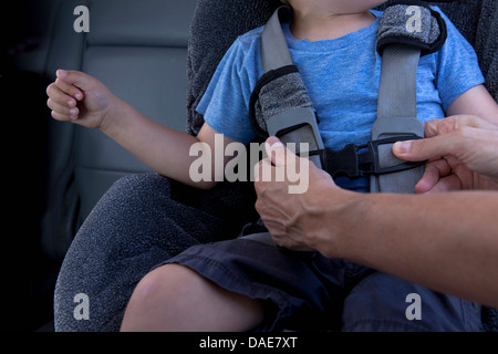 La madre del bambino di fissaggio cintura di sicurezza in auto Foto Stock