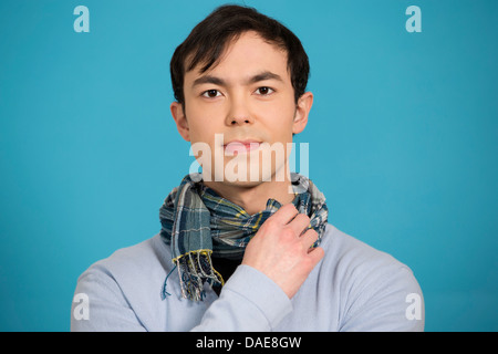 Ritratto di giovane uomo che indossa ponticello blu e sciarpa Foto Stock