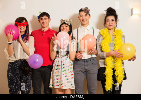 Gli amici a una festa con palloncini, studio shot Foto Stock