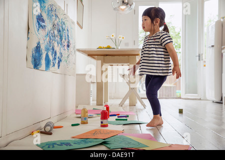 Toddler femmina di ispezionare il suo disegno e pittura Foto Stock