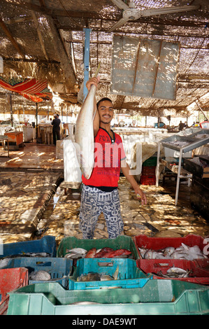 Fish monger presso il mercato del pesce è orgogliosa di presentare un pesce, Egitto, Hurghada Foto Stock