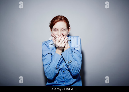 Studio Ritratto di giovane donna sogghignando Foto Stock