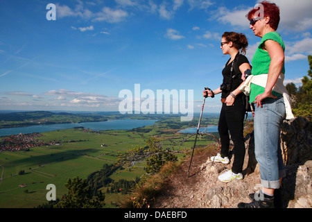 Due donne in piedi su una montagna e guardando al Forggensee, in Germania, in Baviera, Allgaeu, Schwangau Foto Stock