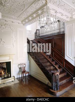 Scalinata in legno di quercia con girata bannister in grand corridoio ornato rococò di intonaco su pareti e soffitto Foto Stock