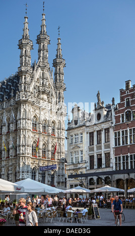 I turisti a caffetterie sulla strada di fronte al municipio gotico al Grote Markt / piazza principale del mercato, Leuven / Louvain, Belgio Foto Stock