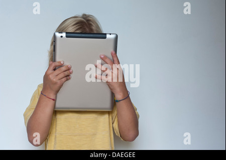 Concetto / Infant boy a casa con la sua testa sepolto nel suo computer tablet "oh" Foto Stock