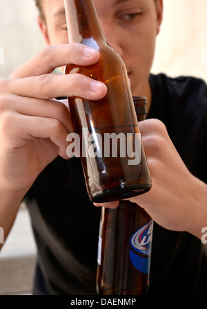 Un 18-anno-vecchio maschio con una bottiglia di birra. Foto Stock