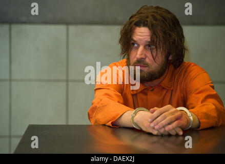 Attore Sascha Alexander Gersak come Murat Kurnaz siede in un set di un camera interogation a come un prigioniero di Guantanamo durante una sessione di stampa circa le riprese di "5 Jahre' ('5 anni") a Babelsberg Studios di Potsdam, Germania, 15 novembre 2011. Il filmato è di circa un innocente uomo Tedesco-turco, che è stato imprigionato per cinque anni presso il campo di prigionia di Guantanamo. Foto: Patrick Pleul Foto Stock