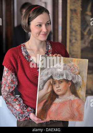 Studente russo Liza Schewtsova presenta una copia del dipinto "Ragazza con Hat' di Pierre-Auguste Renoir in Holzdorf vicino a Weimar, Germania, 17 novembre 2011. Il lavoro è la prima riproduzione del dipinto originale appartenenti alle otto collezione di Krebs. Grazie ad una donazione di 40 000 euro, gli originali che sono esposti presso lo Stato Hermitage di San Pietroburgo dal 1947, c Foto Stock