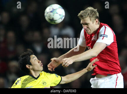 Arsenal Per Mertesacker (r) e Dortmund Shinji Kagawa (l) lotta per la palla durante la Champions League gruppo F partita di calcio tra Arsenal e Borussia Dortmund all'Emirates Stadium di Londra, Gran Bretagna, 23 novembre 2011. Foto: Friso Gentsch dpa +++(c) dpa - Bildfunk+++ Foto Stock