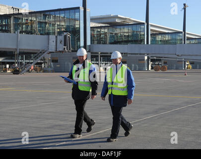 Ralph Rothenhagen (L) e Jens Schwarz dal TÜV Rheinland a piedi passato recentemente costruita jetways presso il nuovo aeroporto di BER in Schoenefeld, Germania, 25 novembre 2011. Al momento, TÜV è che approva la sicurezza dello stato tecnico dell'jetways. Quando l'aeroporto apre il 3 giugno 2012, sarà in grado di gestire circa 27 milioni di passeggeri ogni anno a Berlino. Foto: BERND SETTNIK Foto Stock