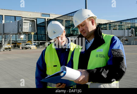 Ralph Rothenhagen (L) e Jens Schwarz dal TÜV Rheinland a piedi passato recentemente costruita jetways presso il nuovo aeroporto di BER in Schoenefeld, Germania, 25 novembre 2011. Al momento, TÜV è che approva la sicurezza dello stato tecnico dell'jetways. Quando l'aeroporto apre il 3 giugno 2012, sarà in grado di gestire circa 27 milioni di passeggeri ogni anno a Berlino. Foto: BERND SETTNIK Foto Stock