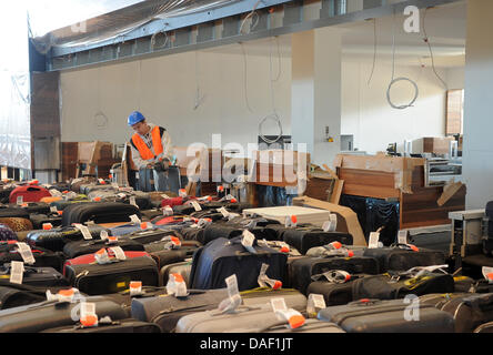 Lavoratori edili prova di portare i bagagli per il check-in presso il nuovo aeroporto di BER in Schoenefeld, Germania, 25 novembre 2011. Al momento, TÜV è che approva la sicurezza dello stato tecnico dell'jetways. Quando l'aeroporto apre il 3 giugno 2012, sarà in grado di gestire circa 27 milioni di passeggeri ogni anno a Berlino. Foto: BERND SETTNIK Foto Stock