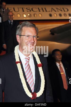 Il Presidente tedesco Christian Wulff riceve una ghirlanda di fiori al suo arrivo all aeroporto di Jakarta, Indonesia, 30 novembre 2011. Wulff visita il Bangladesh e Indonesia durante i suoi sei giorni di visita in Asia. Foto: RAINER JENSEN Foto Stock