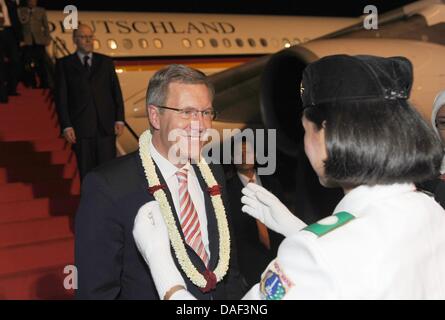 Il Presidente tedesco Christian Wulff riceve una ghirlanda di fiori al suo arrivo all aeroporto di Jakarta, Indonesia, 30 novembre 2011. Wulff visita il Bangladesh e Indonesia durante i suoi sei giorni di visita in Asia. Foto: RAINER JENSEN Foto Stock