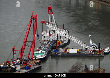 Salvataggio forcers sollevare il rovesciamento chiatta acido vicino a St Goatrshausen, Germania, 13 febbraio 2011. Salvagers domenica ha sollevato una barca che ha parzialmente bloccato il Reno, il più grande di tutta Europa per via navigabile. Il Waldhof, a 110 metri Chiatta motorizzata, è stato recuperare e raddrizzare, un mese dopo averlo capovolto e affondò con la perdita di due vite a un incidente blackspot nell'aspra Gola del Reno Sa Foto Stock