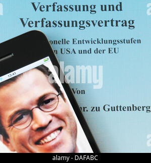 La figura mostra il coperchio del ministro della Difesa tedesco Karl-Theodor zu Guttenberg della tesi di dottorato, sul quale un telefono intelligente che mostra una foto dell'autore è posto, a Berlino, in Germania il 16 febbraio 2011. Dopo diversi controversials per quanto riguarda le riforme delle forze armate tedesche, Guttenberg volti nuovi problemi: il 'Süddeutsche Zeitung" si afferma che egli ha copiato insieme i passaggi per la sua Foto Stock