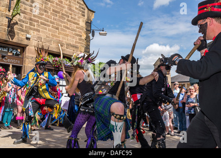 Membri del suino nero confine Morris ballerini e musicisti un variopinto spettacolo di artisti di strada in Bakewell Derbyshire Foto Stock