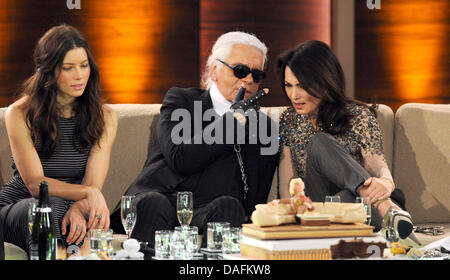 Attrice tedesca Iris Berben (R), il tedesco stilista Karl Lagerfeld (C) e US attrice Jessica Beal sedersi accanto a ogni altro durante la televisione tedesca game show "Wetten Dass,...?" (vuoi scommettere che...?) trasmesso il pubblico tedesco la rete televisiva ZDF all'Rothaus Halle venue in Friedrichshafen, Germania, 3 dicembre 2011. Il spettacolo di intrattenimento è l'edizione finale ospitata da GE Foto Stock